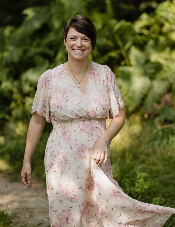 Photo de la doula r'Eve dans les bois avec sa robe qui vole un peu