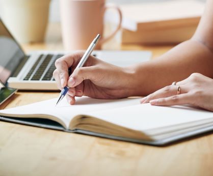 Photo représentant une personne écrivant dans un livre