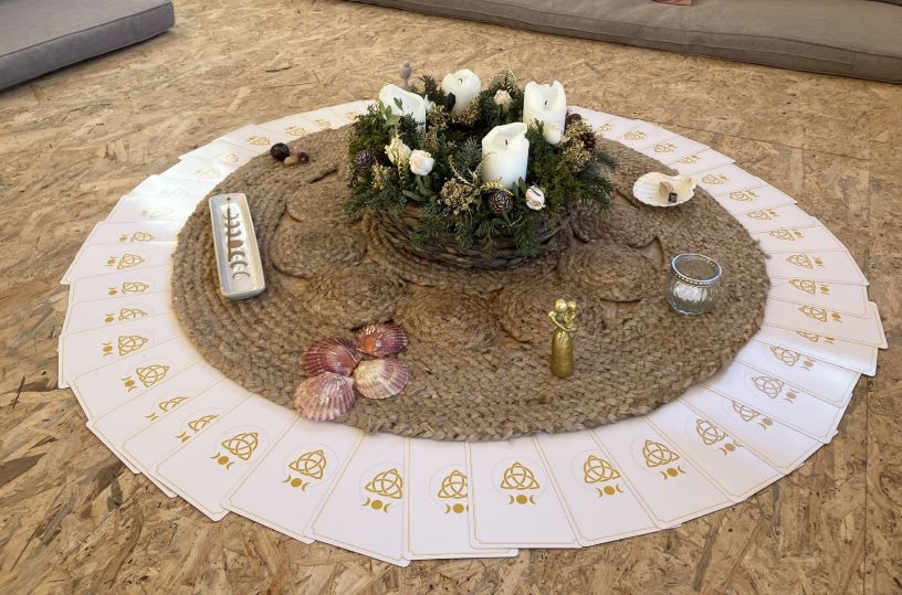 Photo d'un cercle de cartes avec au centre un montage floral avec bougies